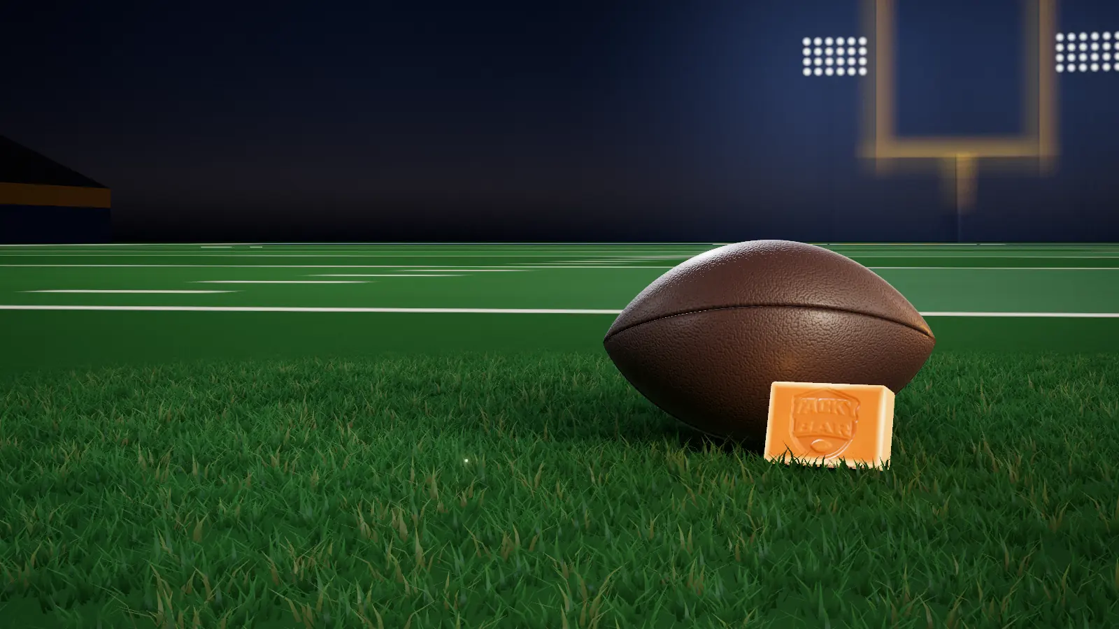 A football and an amber Tacky Bar on a floodlit field at night