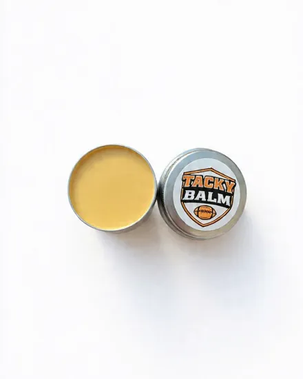 An open tin of Tacky Balm next to its Tacky Balm lid