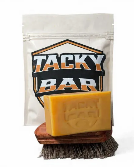 Tacky Bar resting on the wood-backed Tacky Bar brush, in front of a Tacky Bar pouch